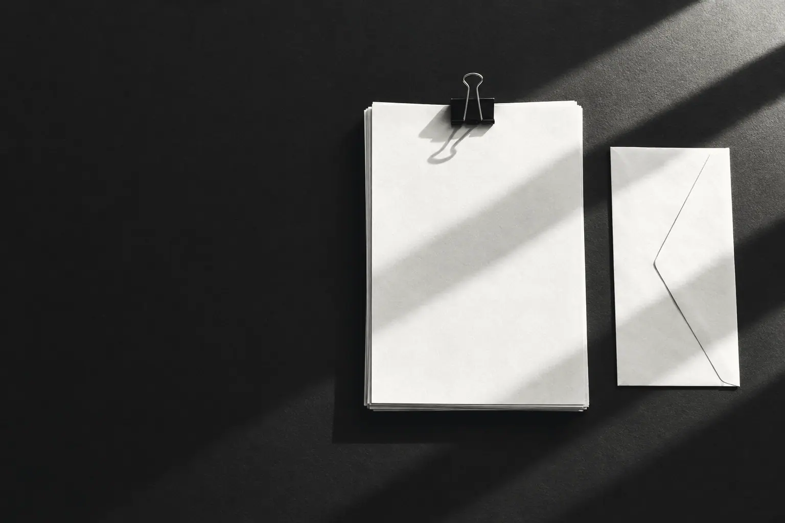 Documents and a sealed envelope on a desk.
